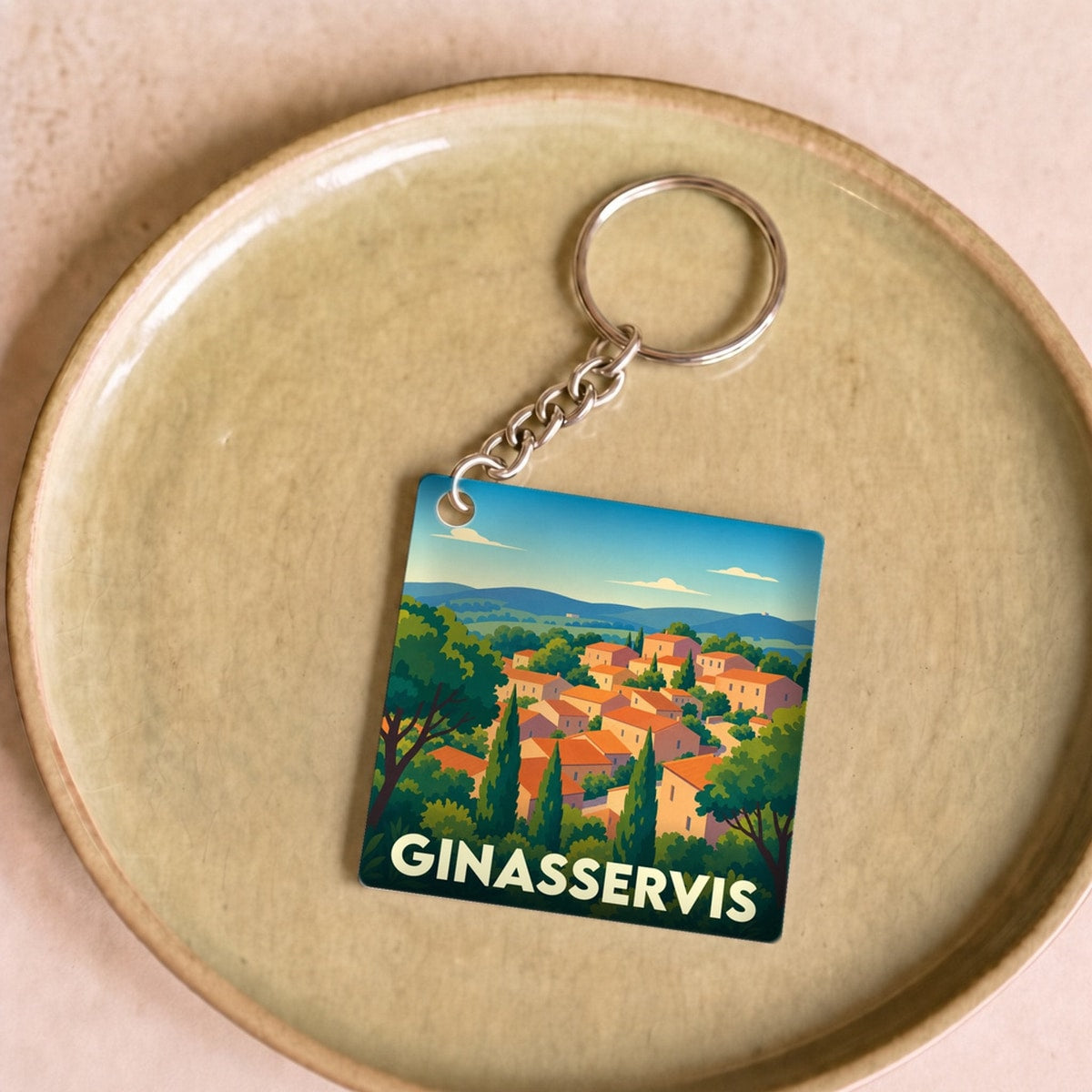 Porte-clés souvenir de la ville de Ginasservis avec une illustration stylisée de son village provençal.