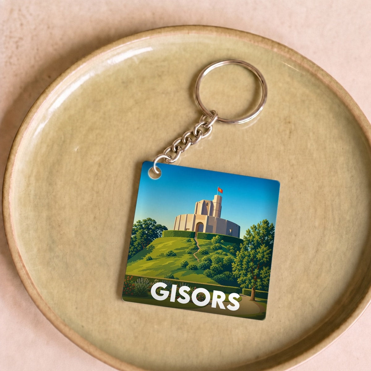 Porte-clés souvenir de la ville de Gisors avec une illustration stylisée du château.