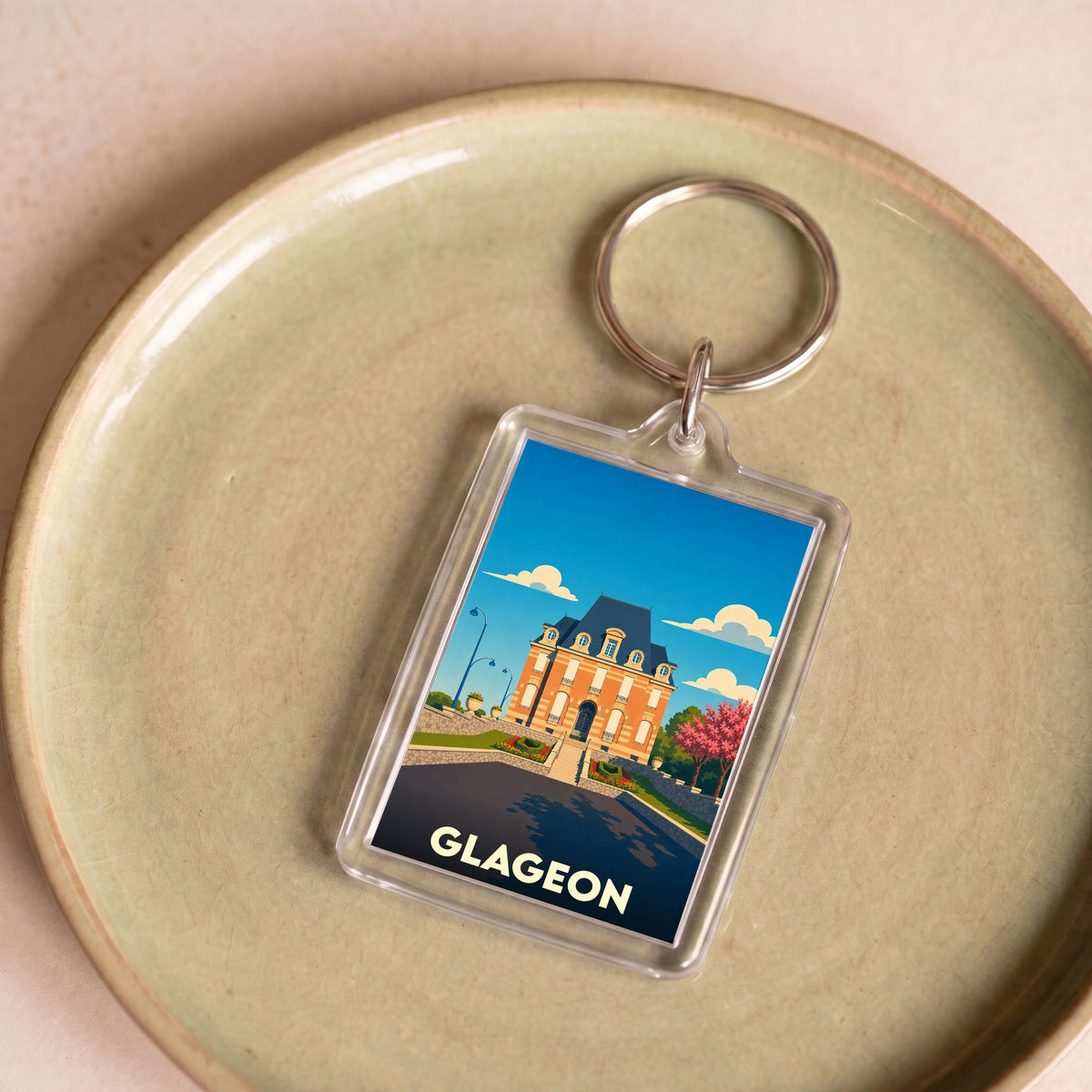 Porte-clés souvenir de la ville de Glageon avec une illustration stylisée de sa mairie.
