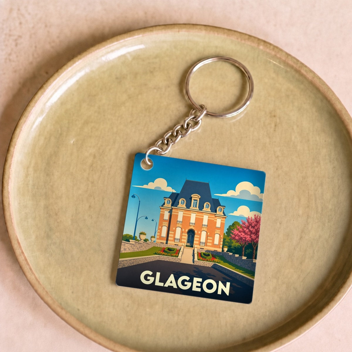 Porte-clés souvenir de la ville de Glageon avec une illustration stylisée de sa mairie.