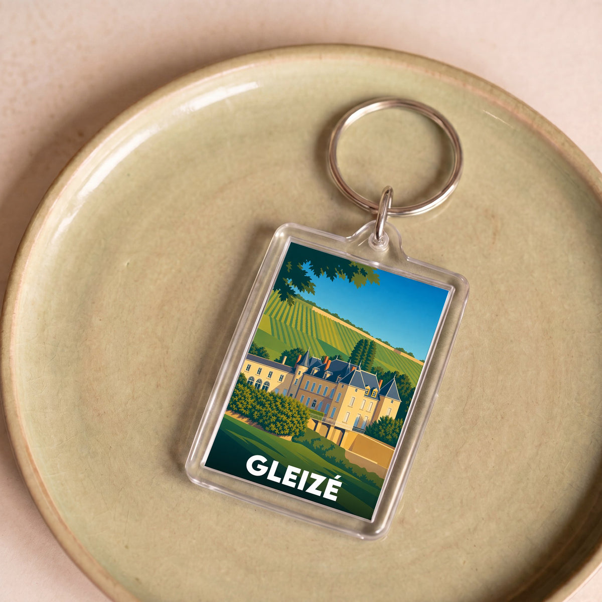 Porte-clés souvenir de la ville de Gleizé avec une illustration stylisée d'un château et de vignobles.