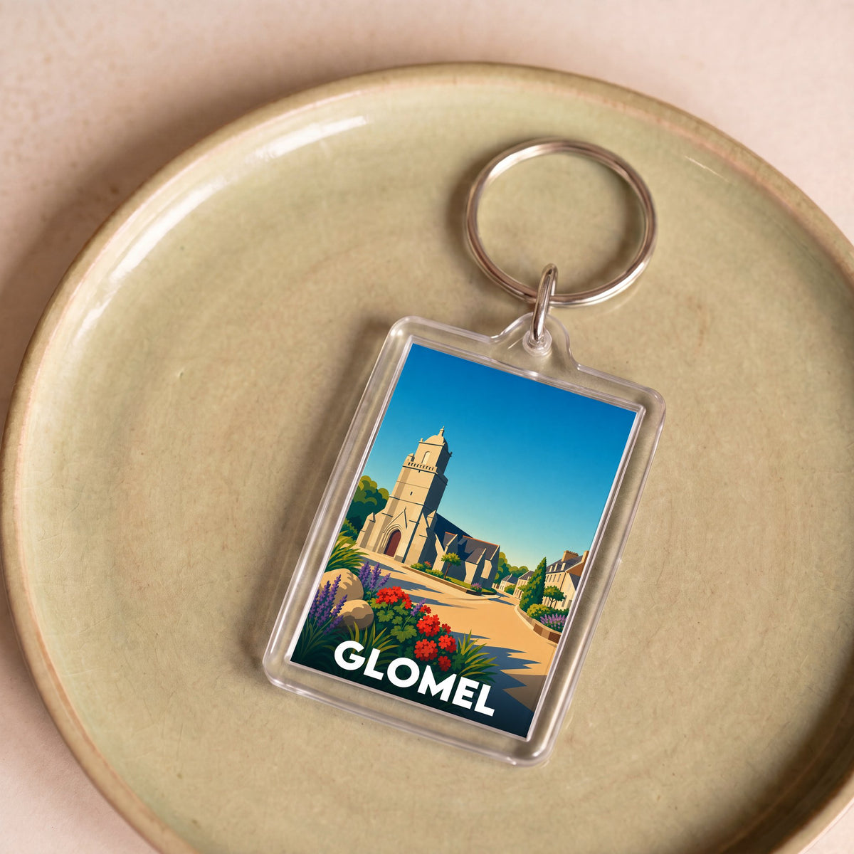 Porte-clés souvenir de la ville de Glomel orné d'une illustration stylisée de son église.