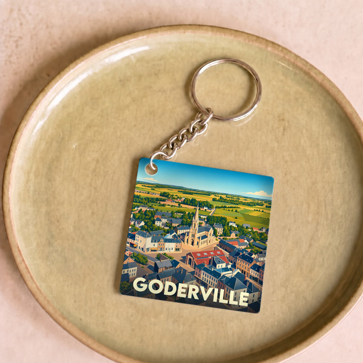 Porte-clés souvenir de la ville de Goderville avec une illustration stylisée vue du ciel.