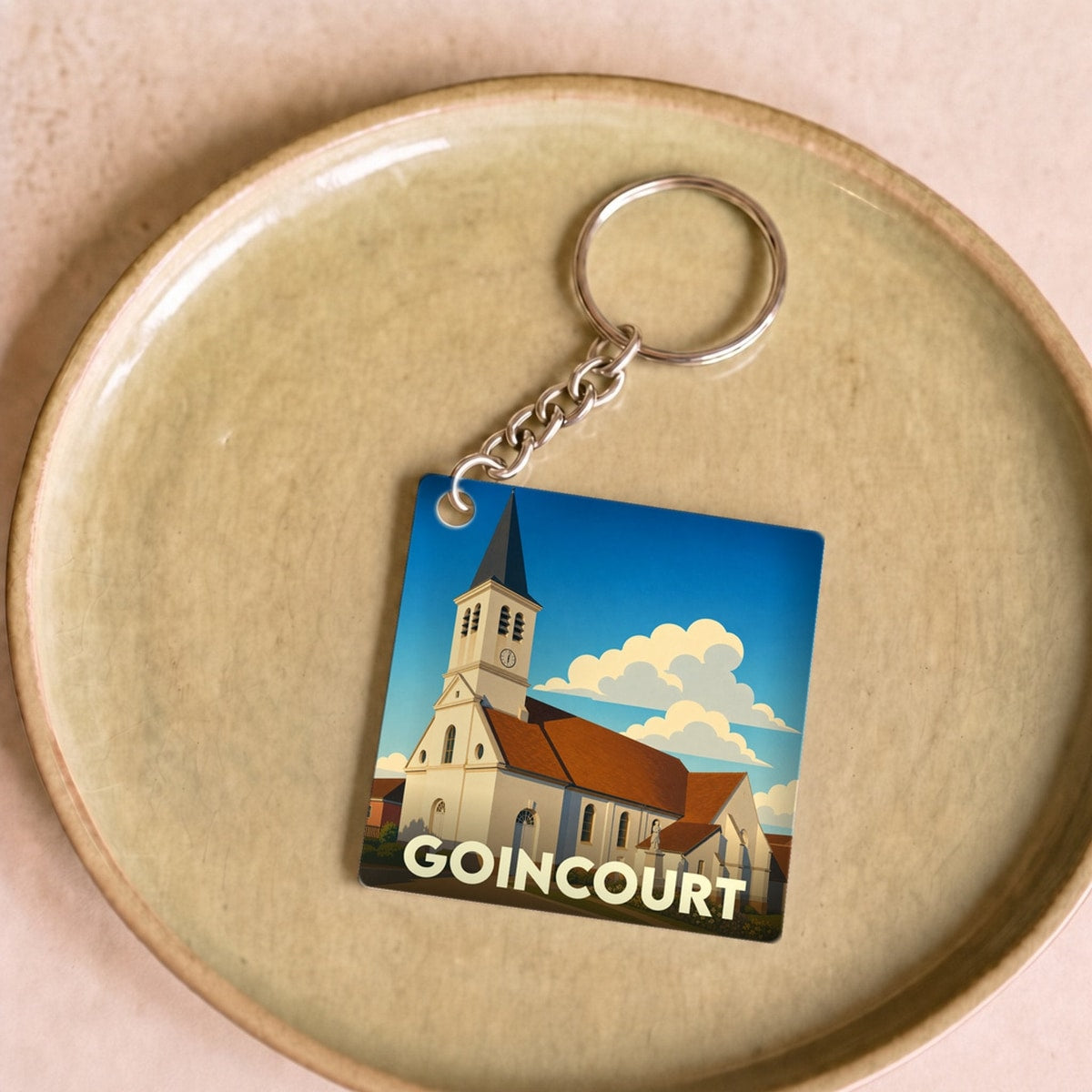 Porte-clés souvenir de la ville de Goincourt avec une illustration stylisée de son église.