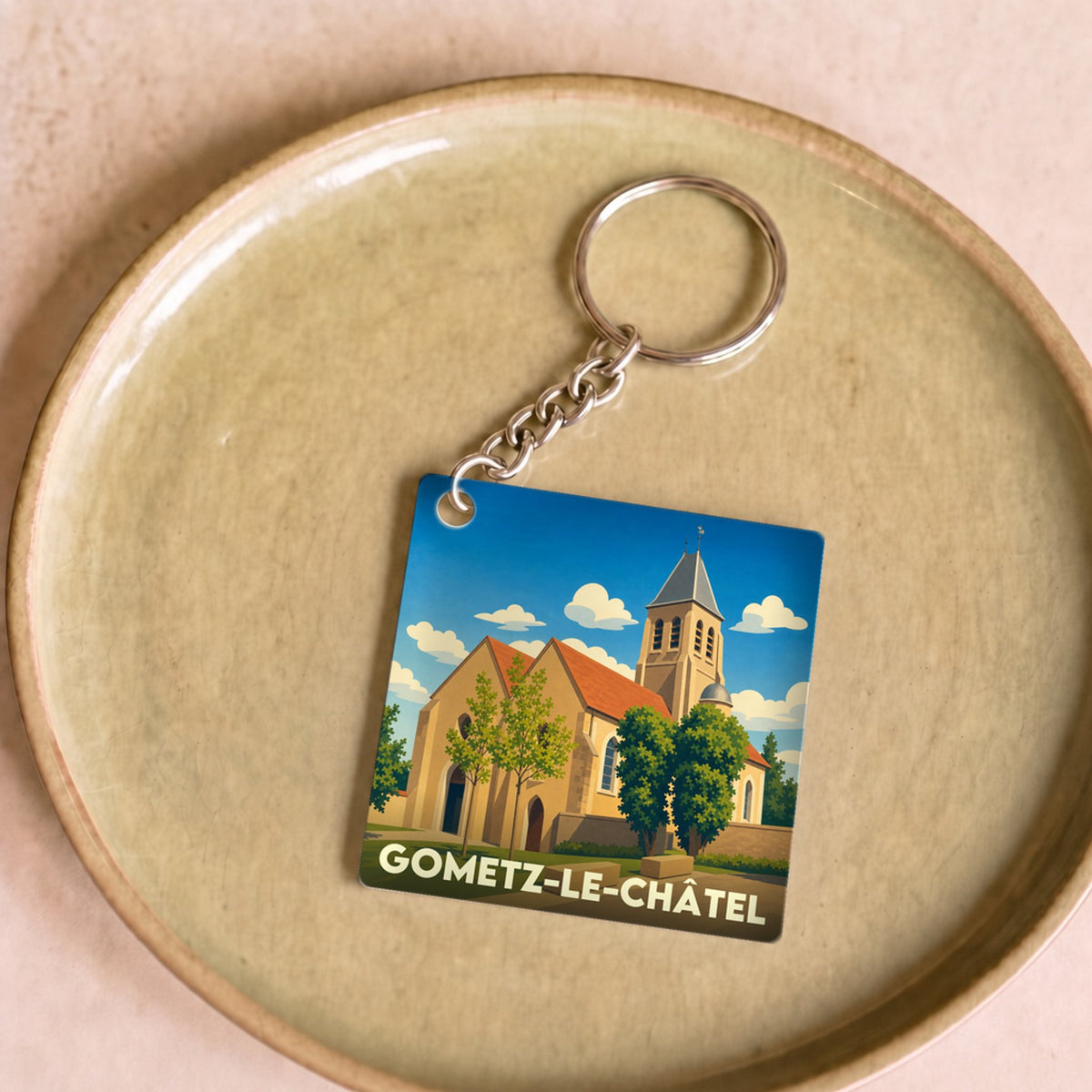 Porte-clés souvenir de la ville de Gometz-le-Châtel avec une illustration stylisée de son église.