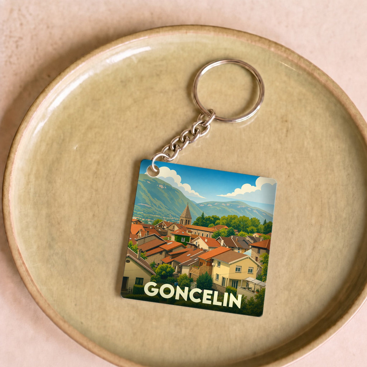 Porte-clés souvenir de la ville de Goncelin avec une illustration stylisée.
