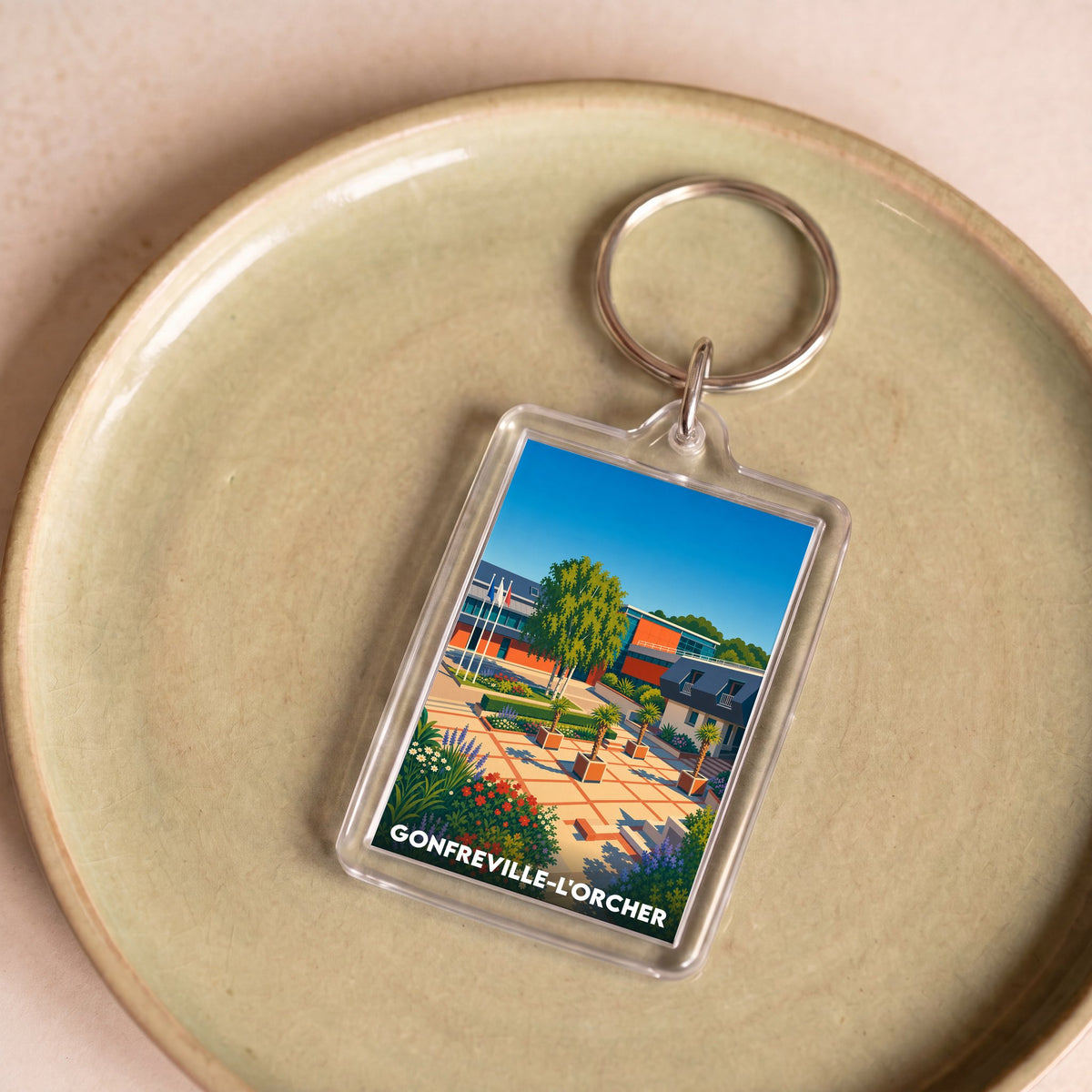 Porte-clés souvenir de la ville de Gonfreville-l'Orcher avec une illustration stylisée.