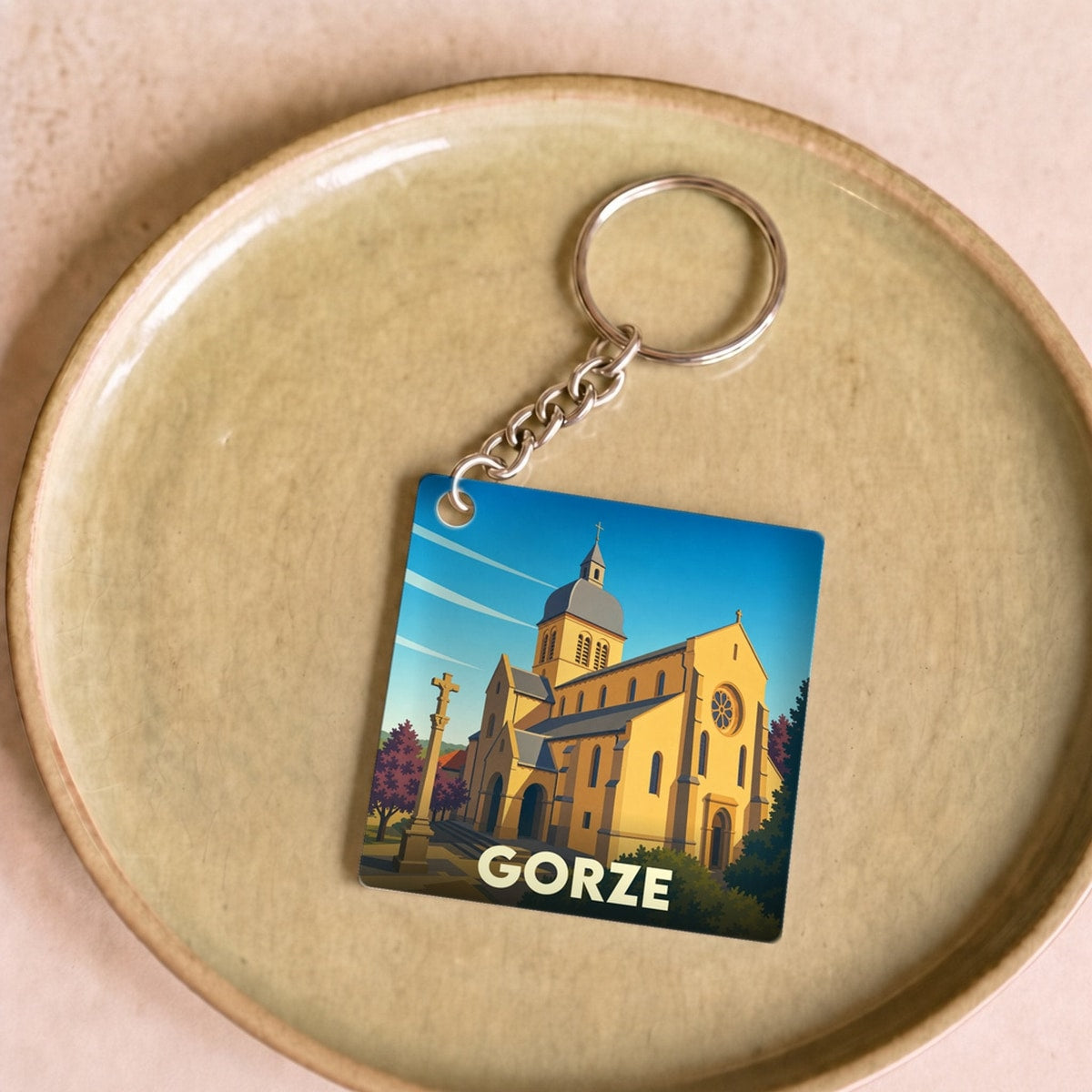 Porte-clés souvenir de la ville de Gorze avec une illustration stylisée de son église.