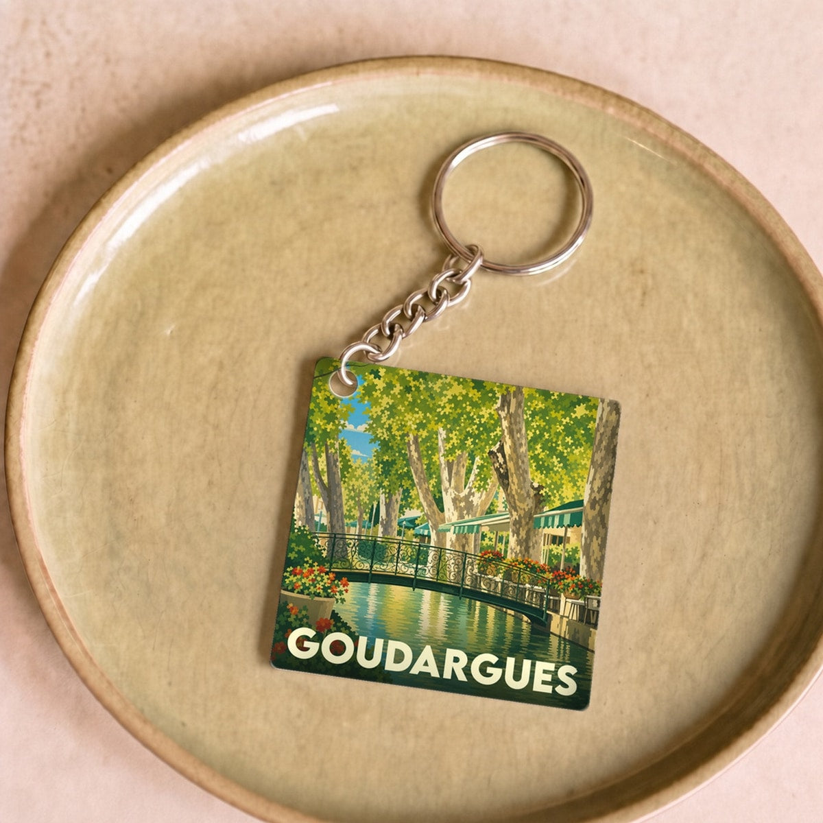 Porte-clés souvenir de la ville de Goudargues avec une illustration stylisée.