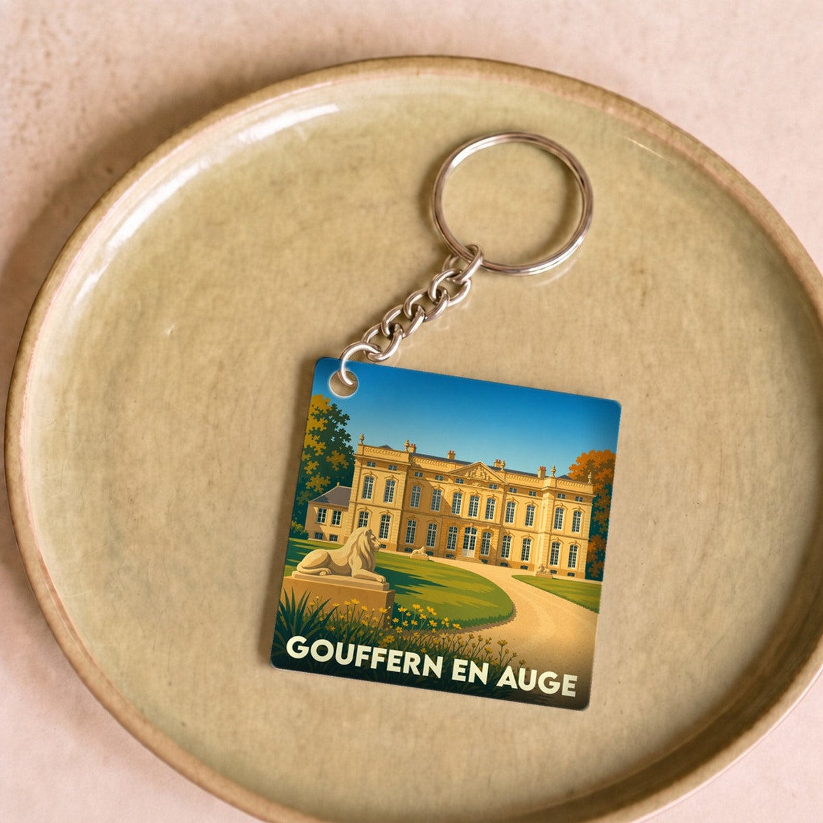 Porte-clés souvenir de la ville de Gouffern en Auge avec une illustration stylisée d'un château.