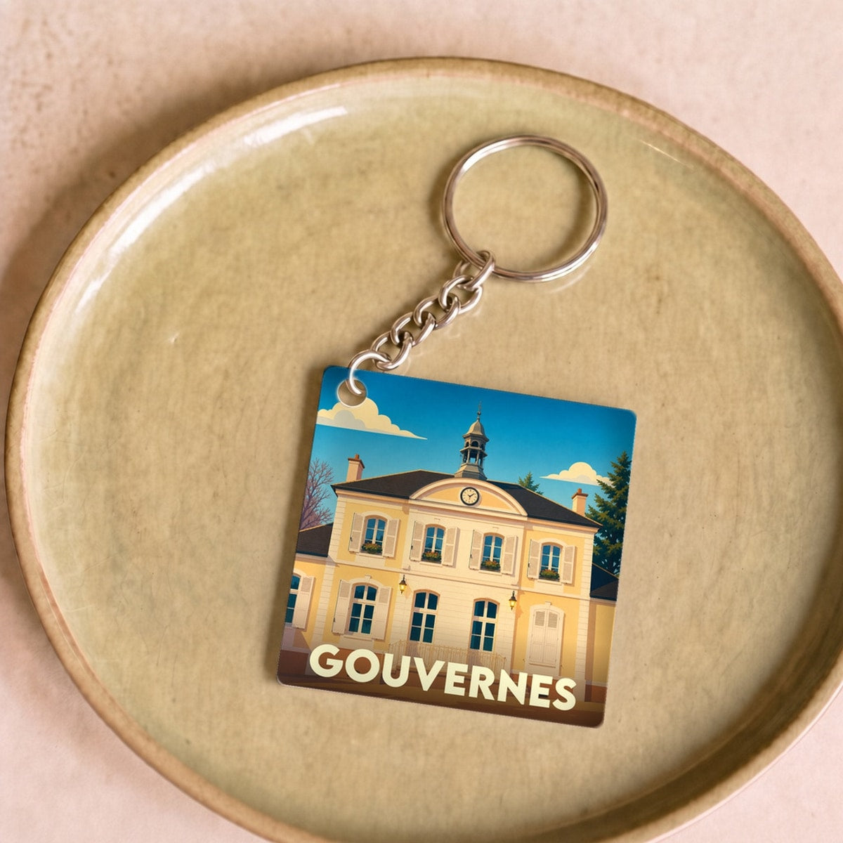 Porte-clés souvenir de la ville de Gouvernes avec une illustration stylisée de sa mairie.