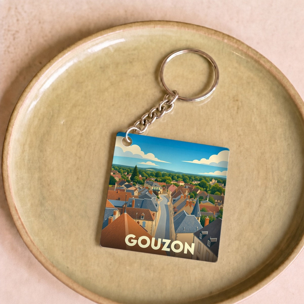 Porte-clés souvenir de la ville de Gouzon avec une illustration stylisée.