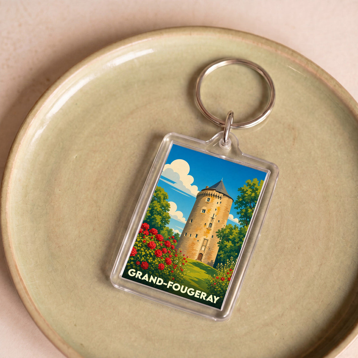 Porte-clés souvenir de la ville de Grand-Fougeray avec une illustration stylisée de sa tour médiévale et de rosiers.