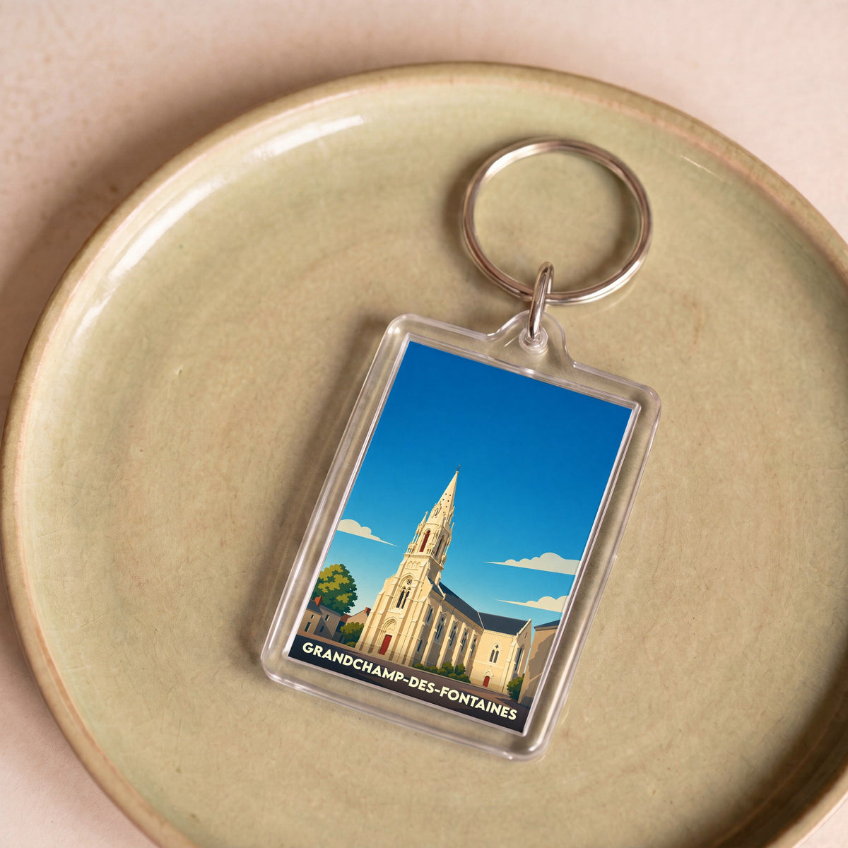 Porte-clés souvenir de la ville de Grandchamp-des-Fontaines avec une illustration stylisée de son église.