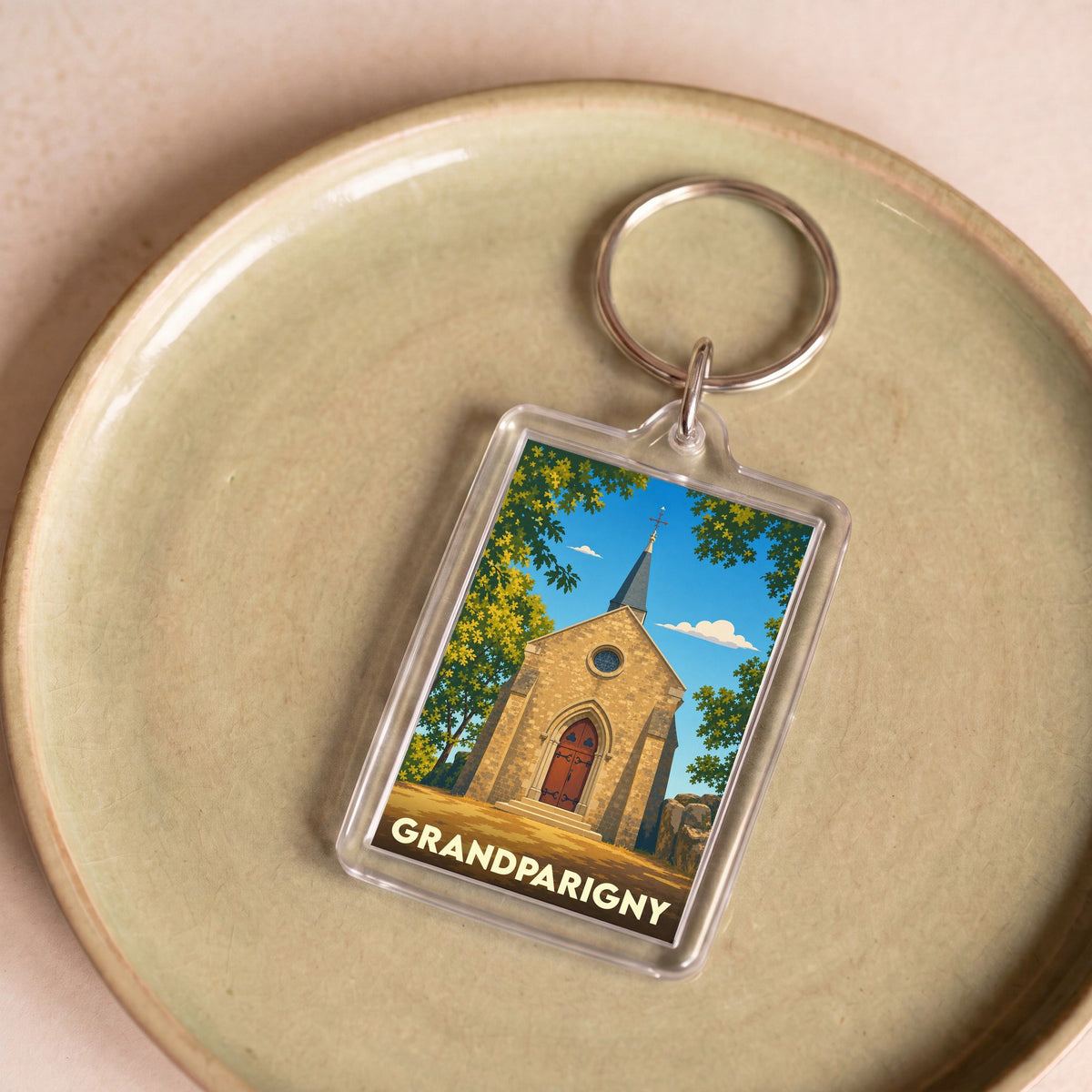Porte-clés souvenir de la ville de Grandparigny avec une illustration stylisée de son église.