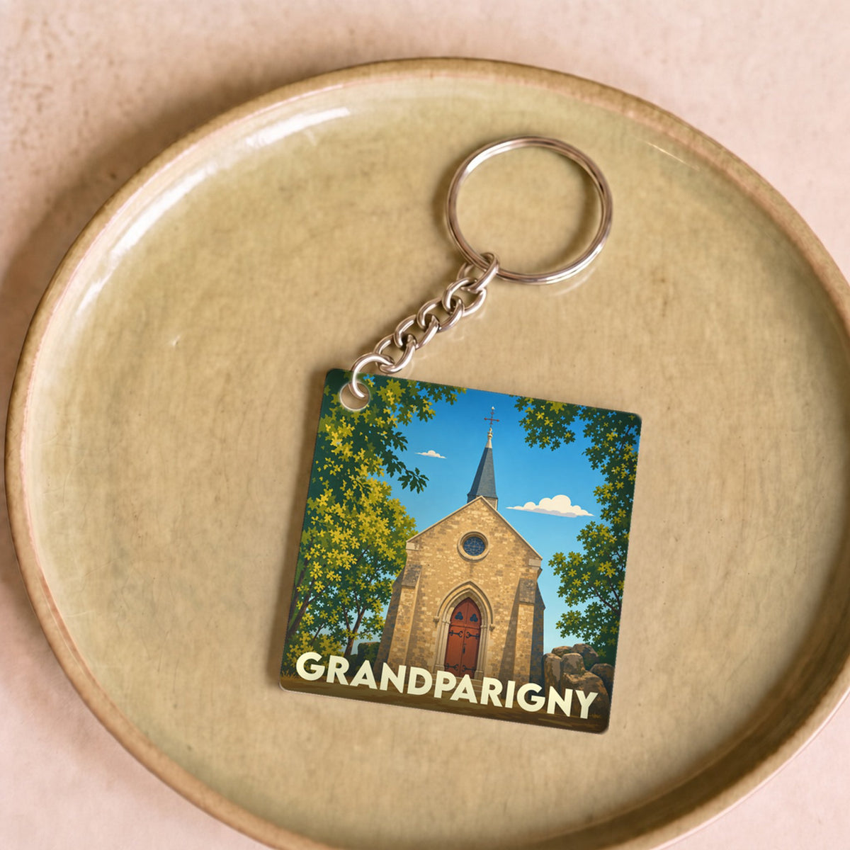 Porte-clés souvenir de la ville de Grandparigny avec une illustration stylisée de son église.