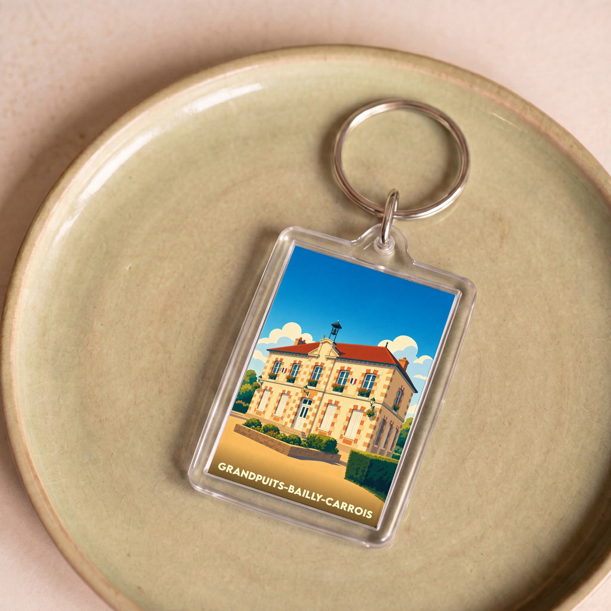 Porte-clés souvenir de la ville de Grandpuits-Bailly-Carrois avec une illustration stylisée.