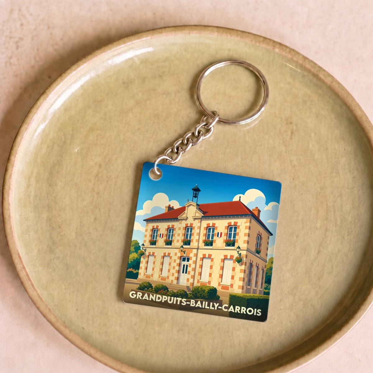 Porte-clés souvenir de la ville de Grandpuits-Bailly-Carrois avec une illustration stylisée.
