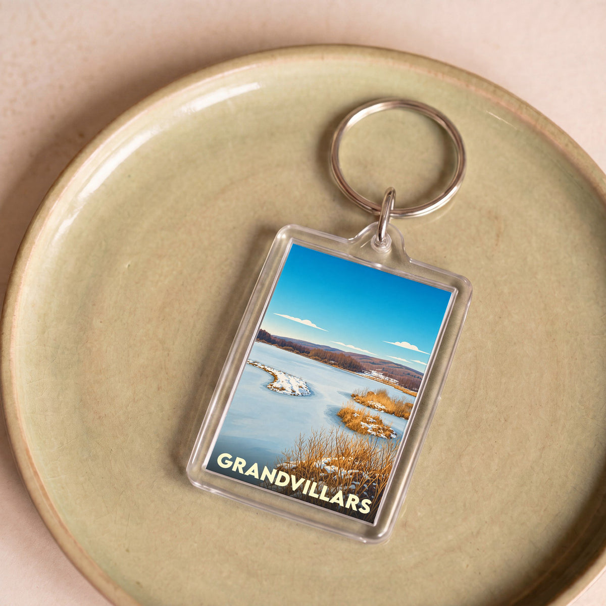 Porte-clés souvenir de la ville de Grandvillars avec une illustration hivernale stylisée.