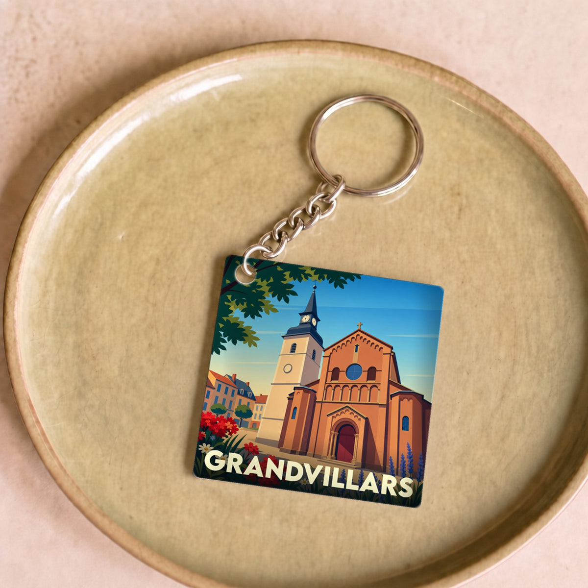 Porte-clés souvenir de la ville de Grandvillars avec une illustration stylisée de son église.
