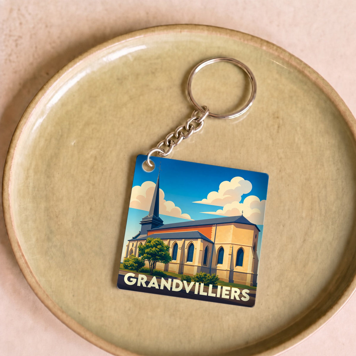Porte-clés souvenir de la ville de Grandvilliers avec une illustration stylisée de son église.