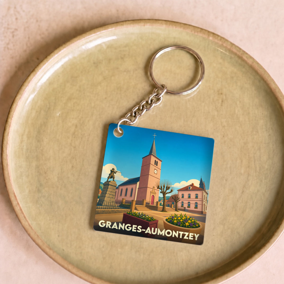 Porte-clés souvenir de la ville de Granges-Aumontzey avec une illustration stylisée.
