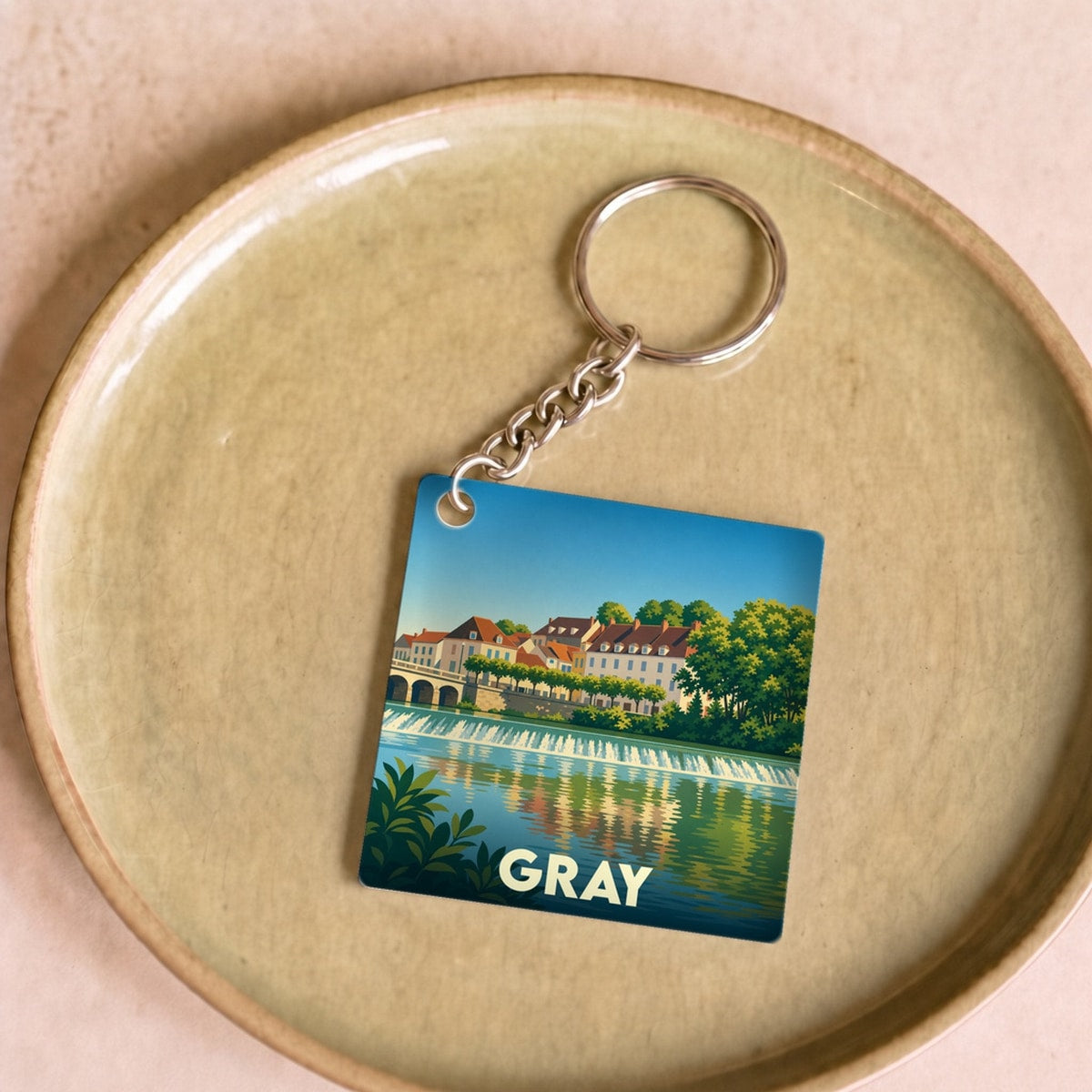 Porte-clés souvenir de la ville de Gray avec une illustration stylisée de ses quais et de la Saône.