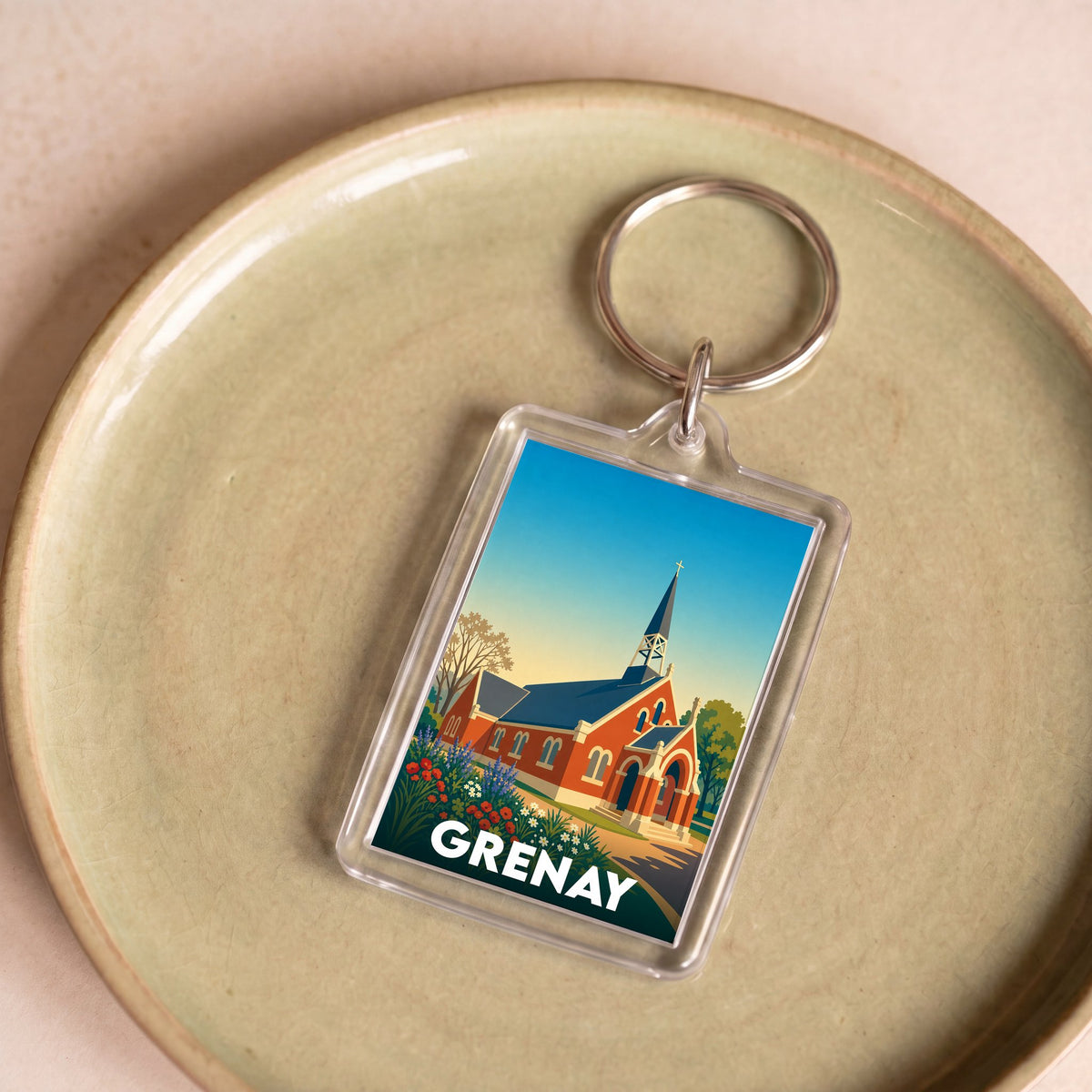 Porte-clés souvenir de la ville de Grenay avec une illustration stylisée de son église.