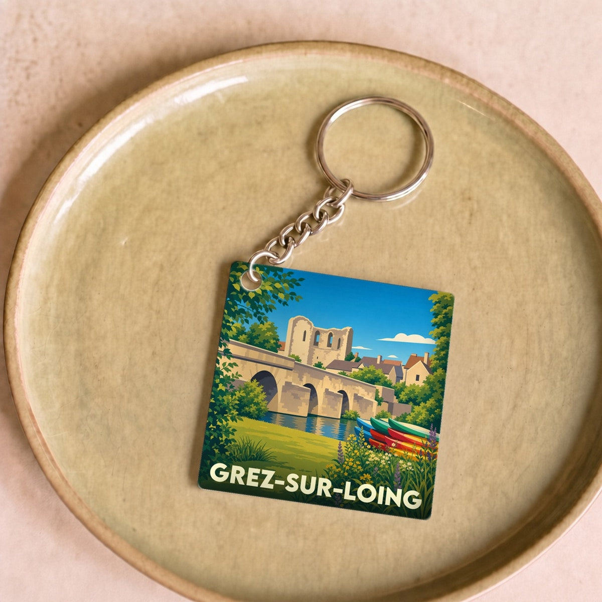 Porte-clés souvenir de la ville de Grez-sur-Loing avec une illustration stylisée.