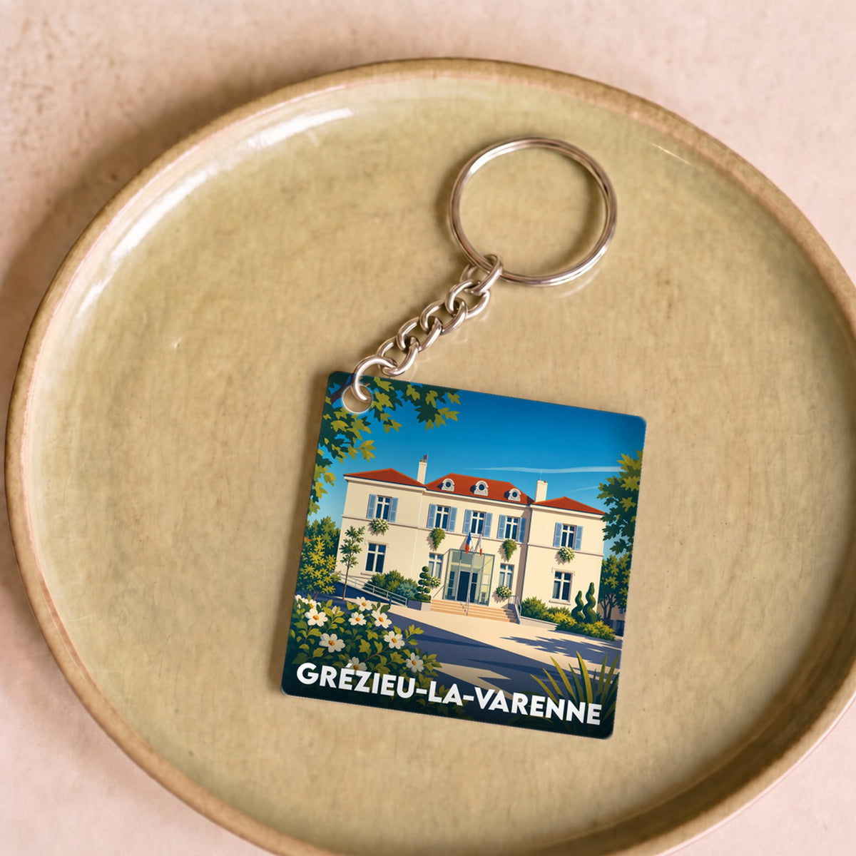 Porte-clés souvenir de la ville de Grézieu-la-Varenne avec une illustration stylisée de sa mairie.
