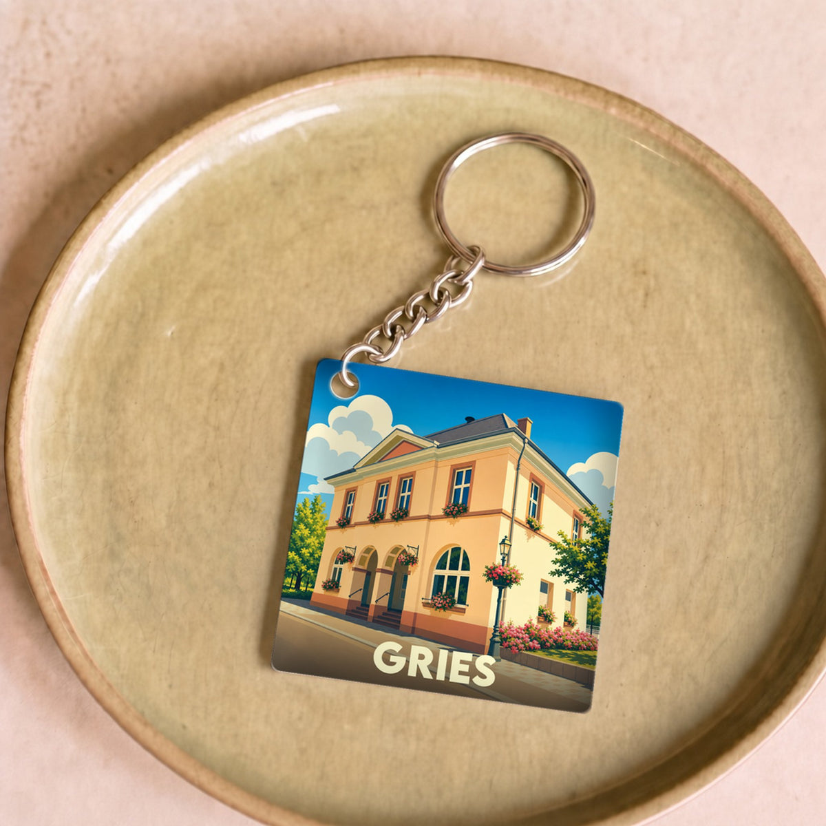 Porte-clés souvenir de la ville de Gries avec une illustration stylisée.