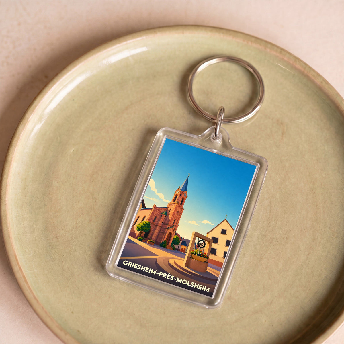 Porte-clés souvenir de la ville de Griesheim-près-Molsheim avec une illustration stylisée.