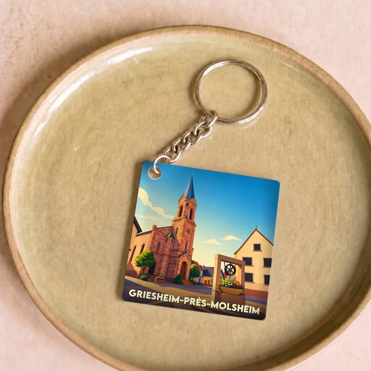 Porte-clés souvenir de la ville de Griesheim-près-Molsheim avec une illustration stylisée.