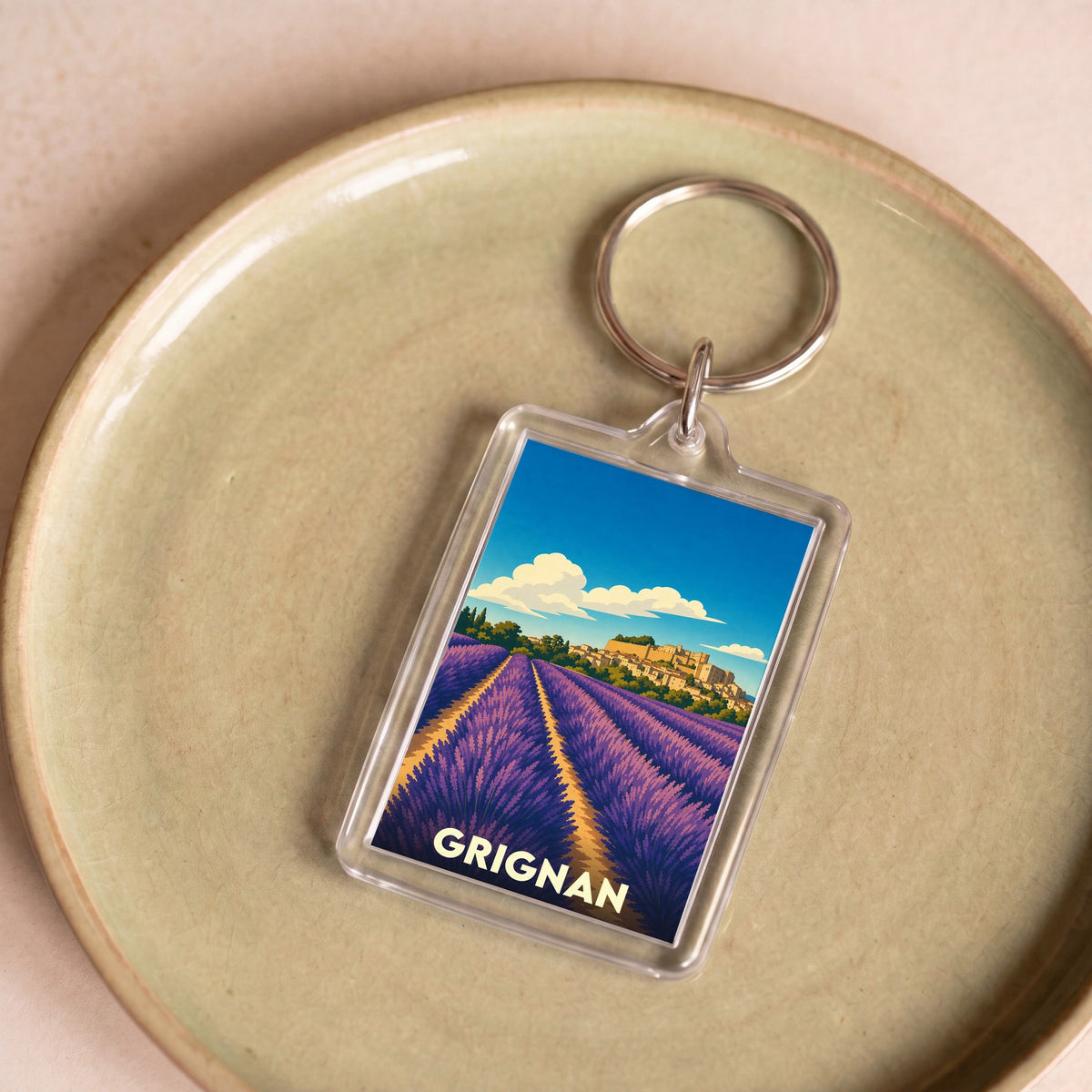 Porte-clés souvenir de la ville de Grignan avec une illustration stylisée de champs de lavande.