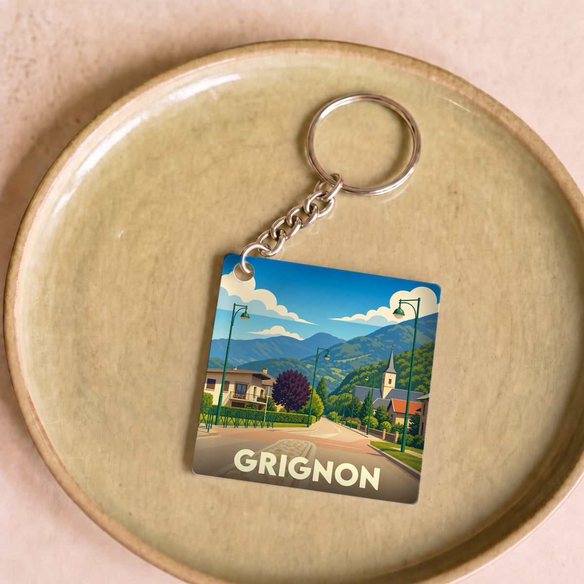 Porte-clés souvenir de la ville de Grignon avec une illustration stylisée de son paysage.