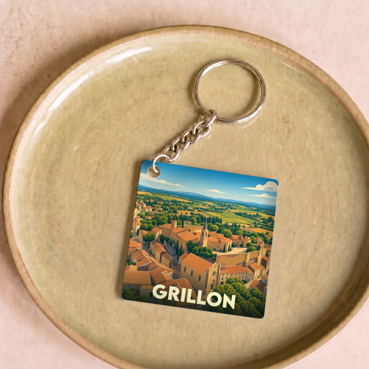Porte-clés souvenir de la ville de Grillon avec une illustration stylisée.
