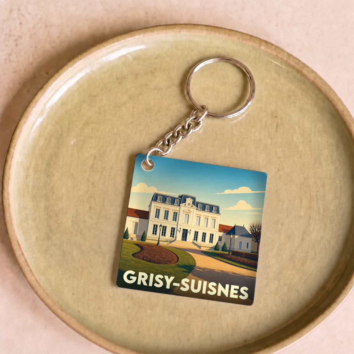 Porte-clés souvenir de la ville de Grisy-Suisnes avec une illustration stylisée d'un château.