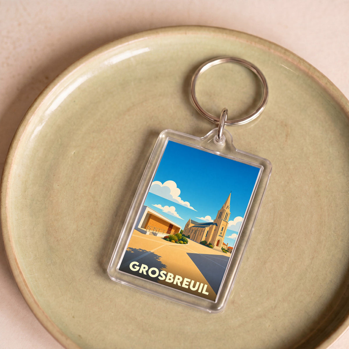 Porte-clés souvenir de la ville de Grosbreuil avec une illustration stylisée de son église.