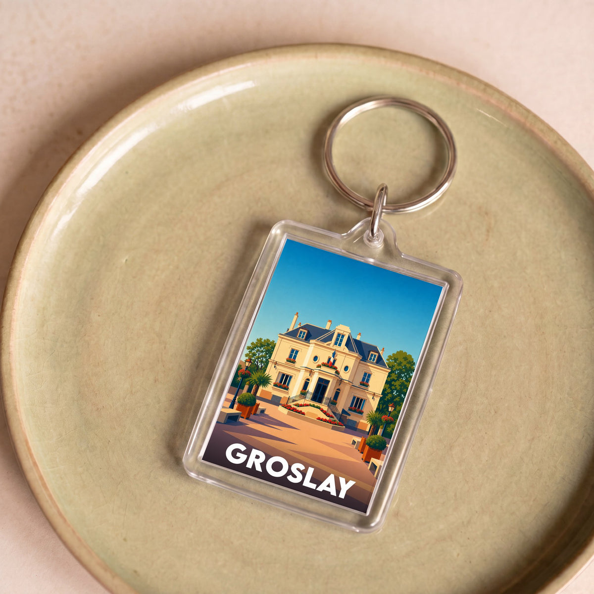 Porte-clés souvenir de la ville de Groslay avec une illustration stylisée d'une bâtisse historique.
