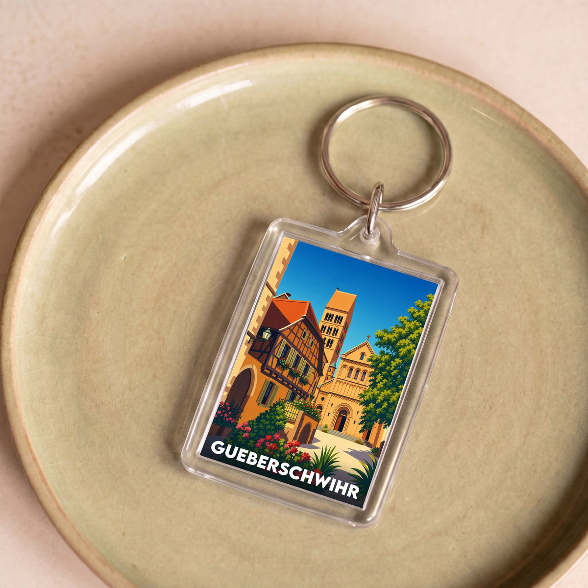 Porte-clés souvenir de la ville de Gueberschwihr avec une illustration stylisée.