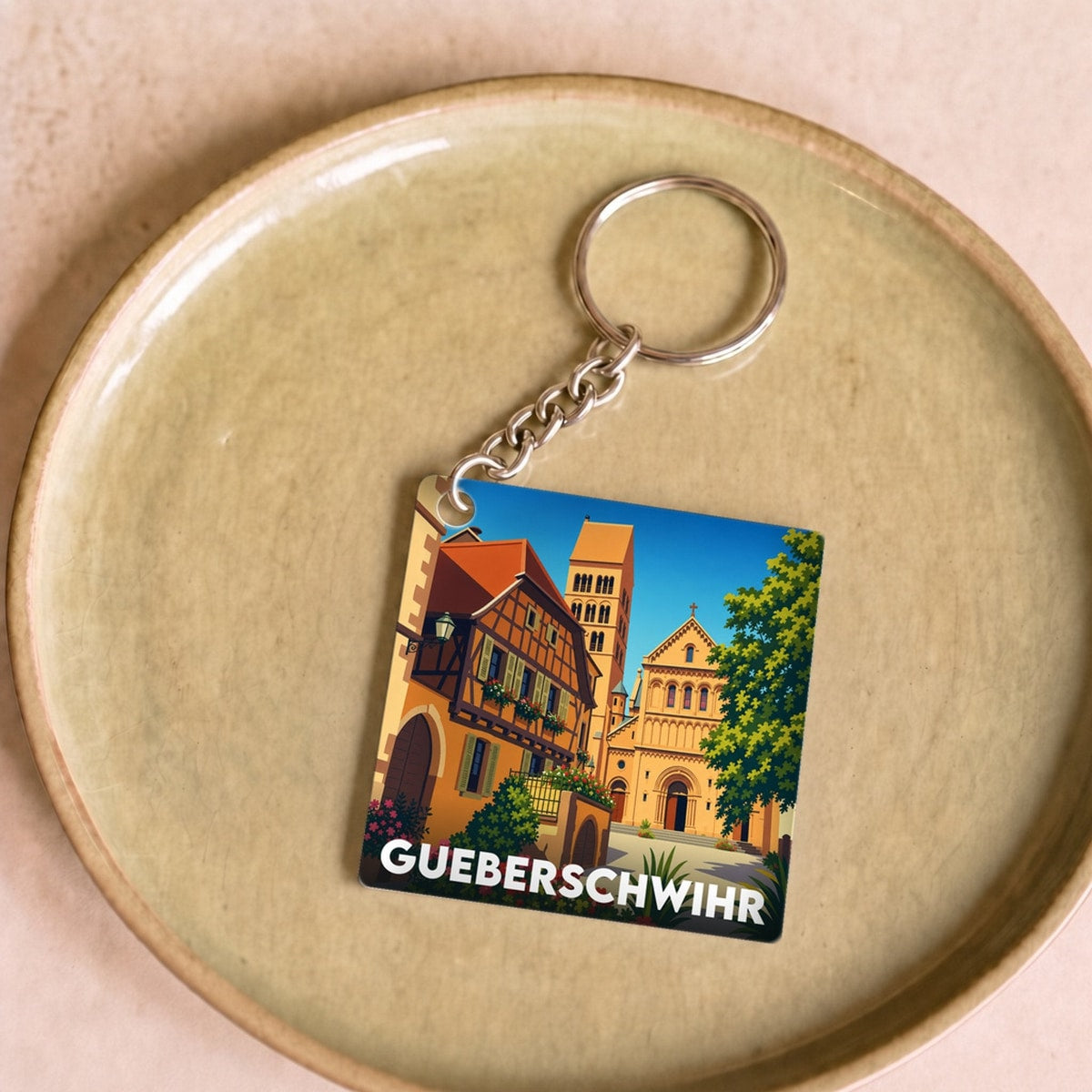 Porte-clés souvenir de la ville de Gueberschwihr avec une illustration stylisée.