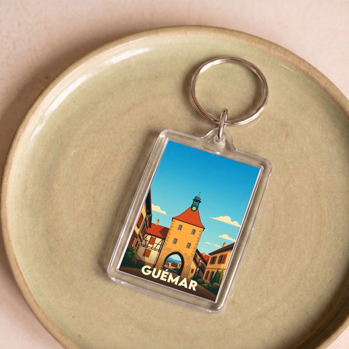 Porte-clés souvenir de la ville de Guémar avec une illustration stylisée.