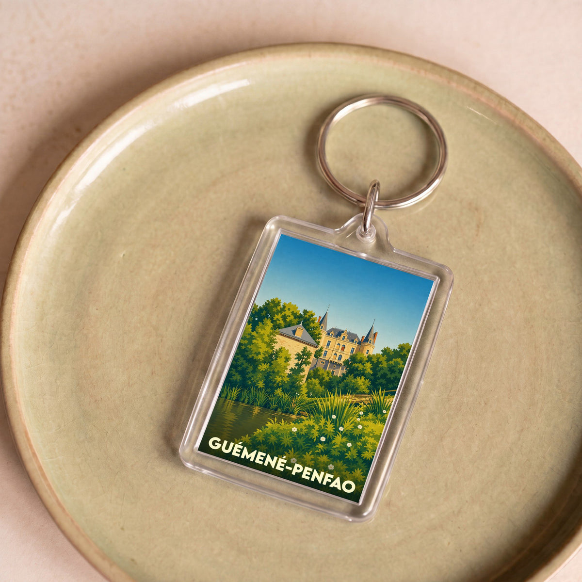 Porte-clés souvenir de la ville de Guémené-Penfao avec une illustration stylisée de son patrimoine.