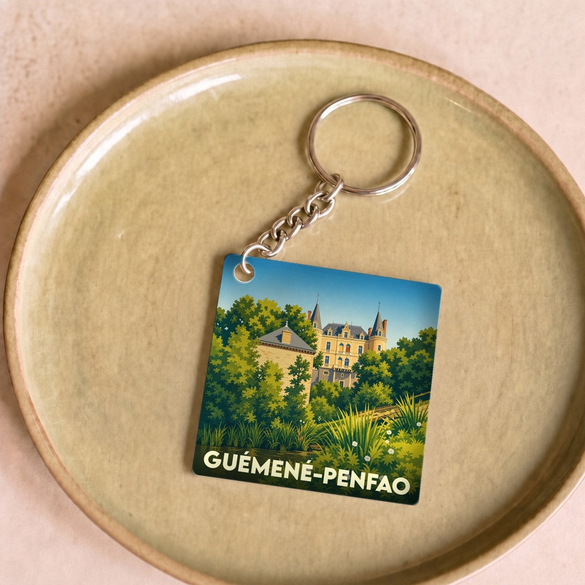 Porte-clés souvenir de la ville de Guémené-Penfao avec une illustration stylisée de son patrimoine.