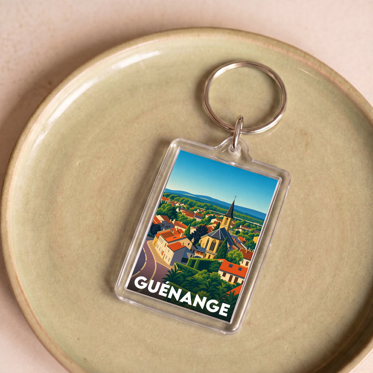 Porte-clés souvenir de la ville de Guénange avec une illustration stylisée.