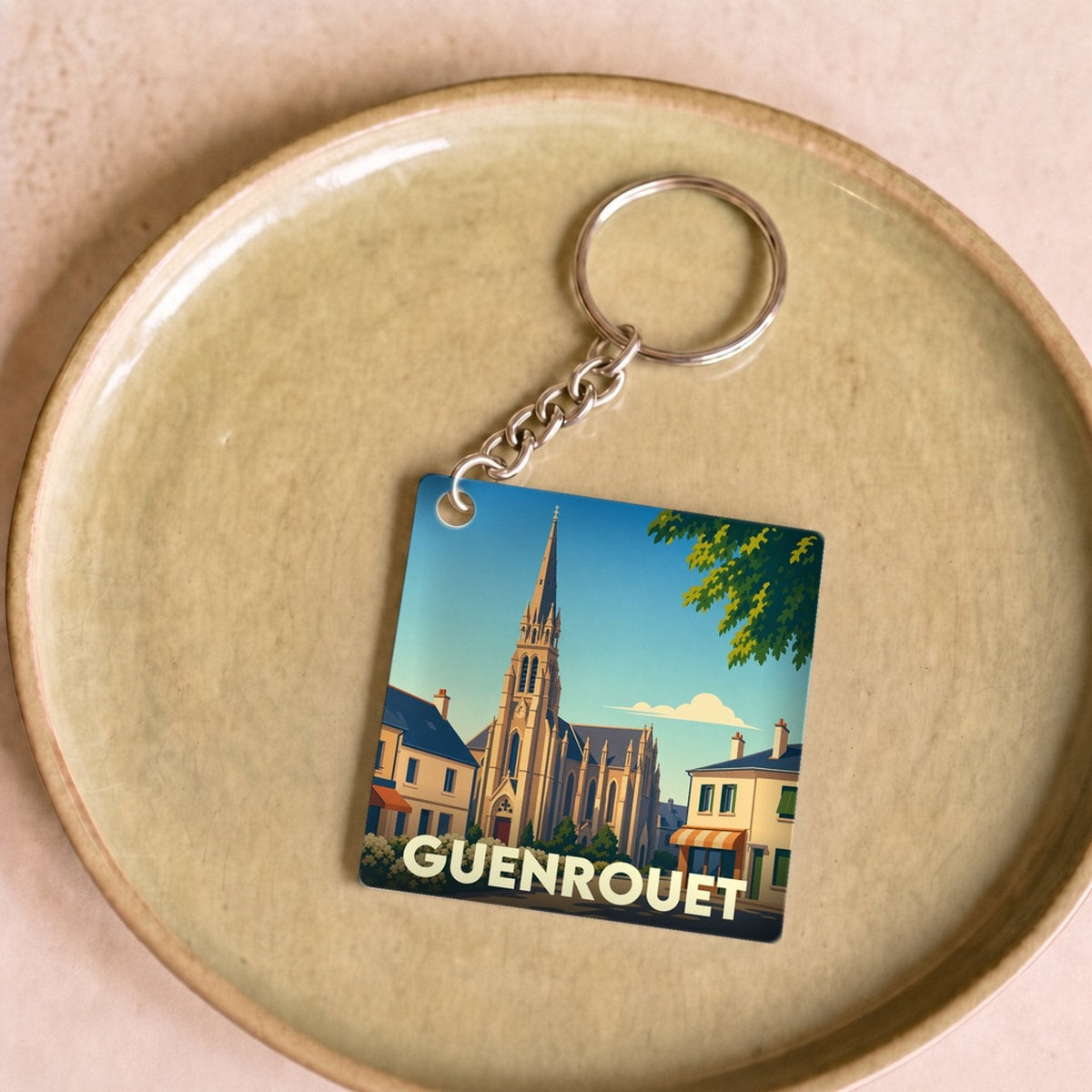Porte-clés souvenir de la ville de Guenrouet avec une illustration stylisée de son église.