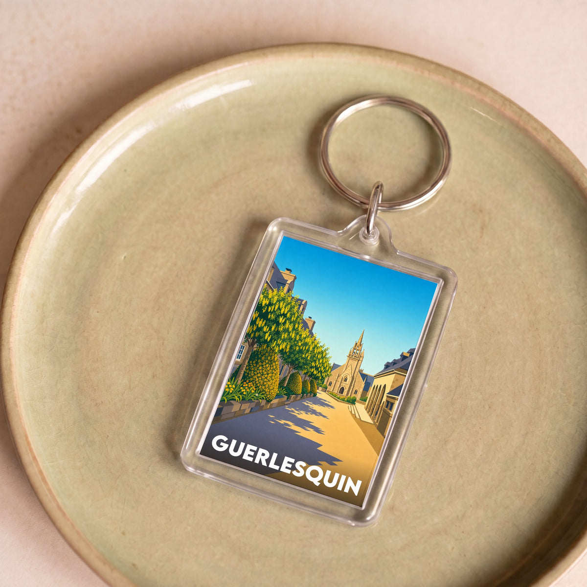 Porte-clés souvenir de la ville de Guerlesquin avec une illustration stylisée.