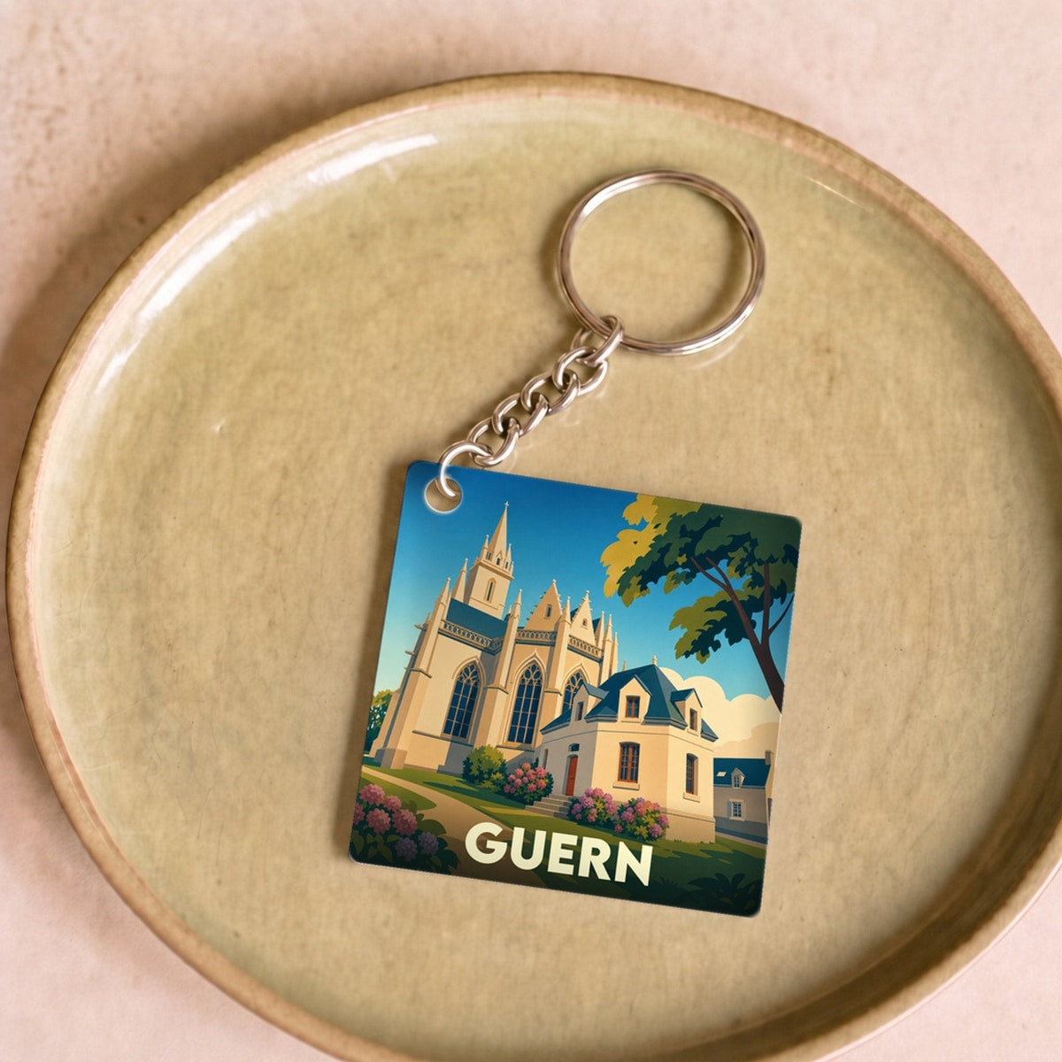 Porte-clés souvenir de la ville de Guern avec une illustration stylisée de son église.