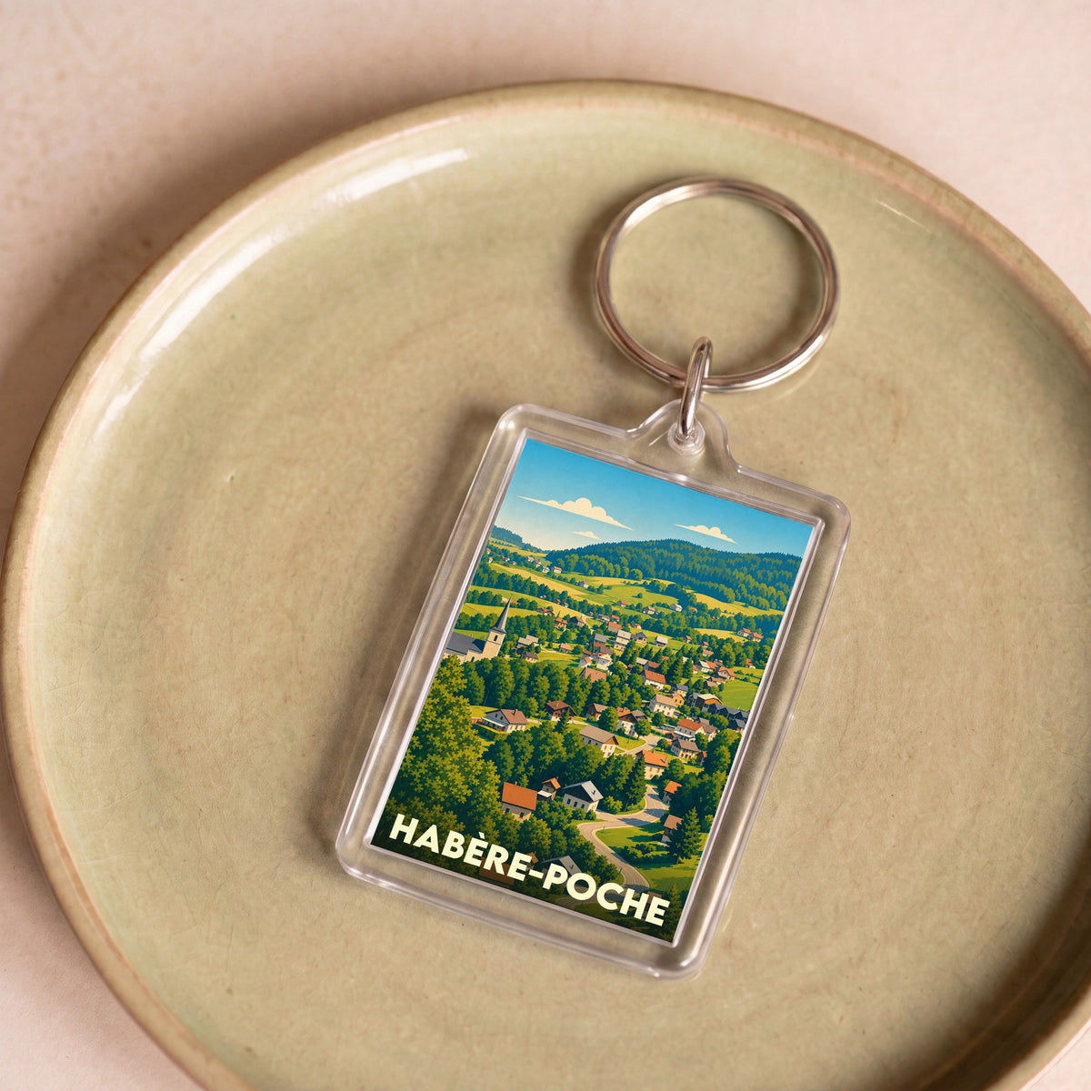 Porte-clés souvenir de la ville de Habère-Poche avec une illustration de paysage de montagne colorée.