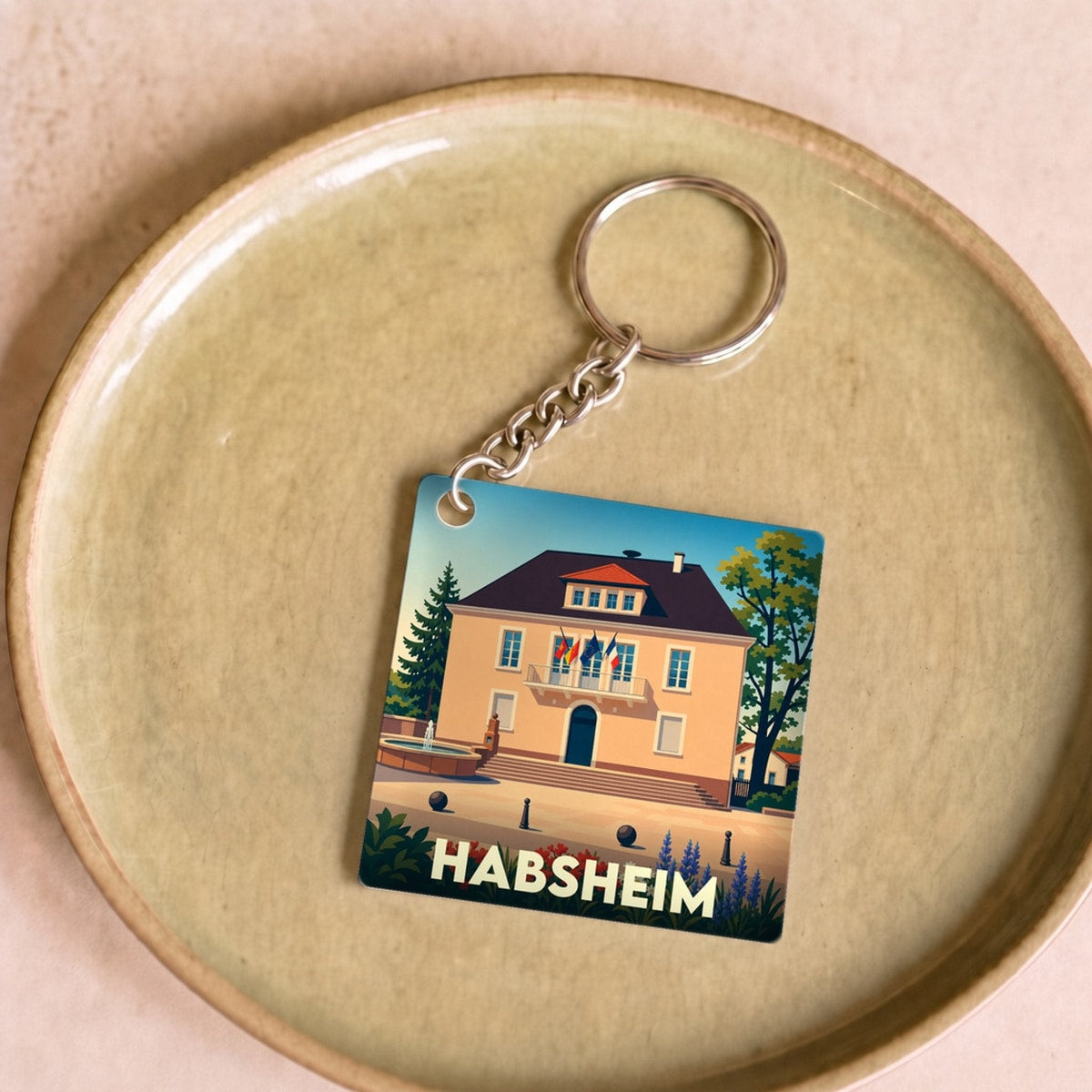 Porte-clés souvenir de la ville de Habsheim avec une illustration stylisée de sa mairie.